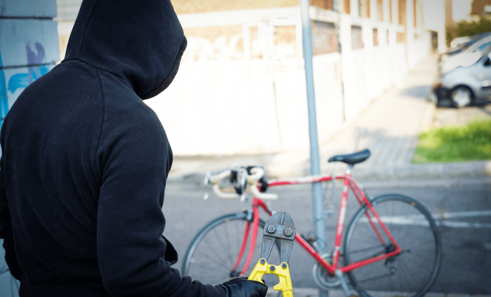 Bicycle thief about to cut a bike chain with pliers