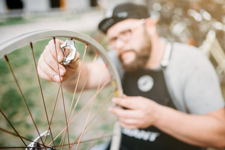 Bicycle mechanic adjusting bike spokes