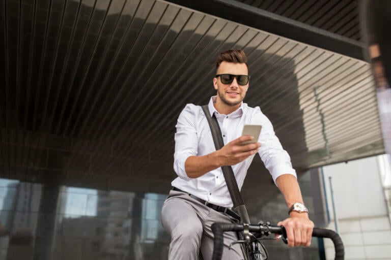 Man on his bicycle and looking at his smartphone