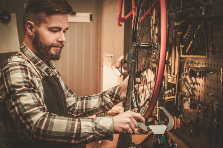 Bicycle mechanic working on a bicycle tire and spokes
