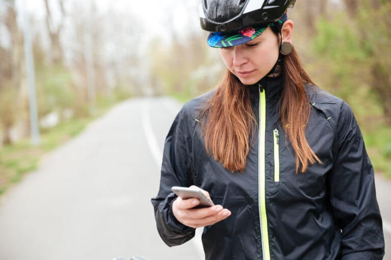 Woman wearing a bicycle helmet and texting