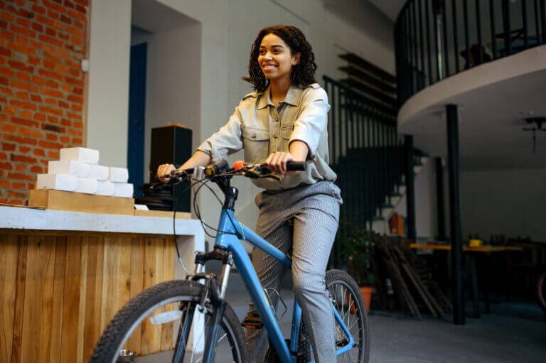 Millennial woman on a bicycle in an office