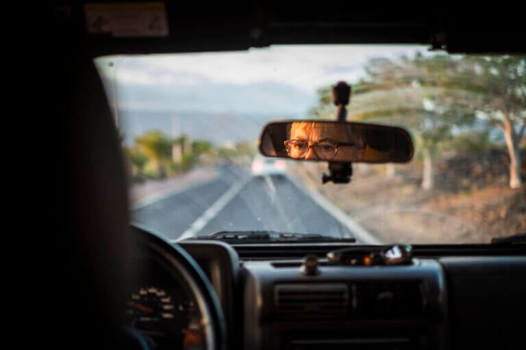Man in the reflection of his rear view mirror while driving
