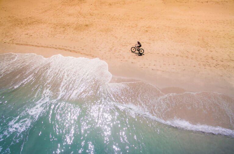 Cyclist riding along the beach
