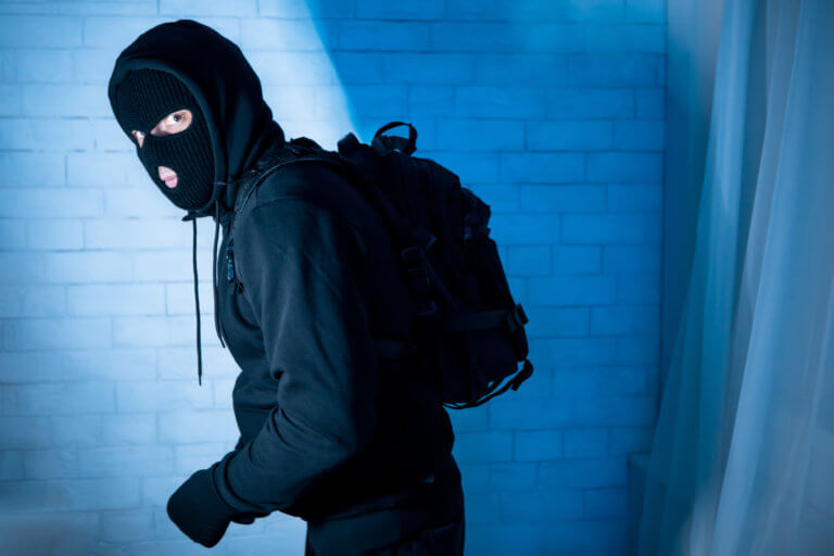 Burglar wearing a mask and black sweatshirt