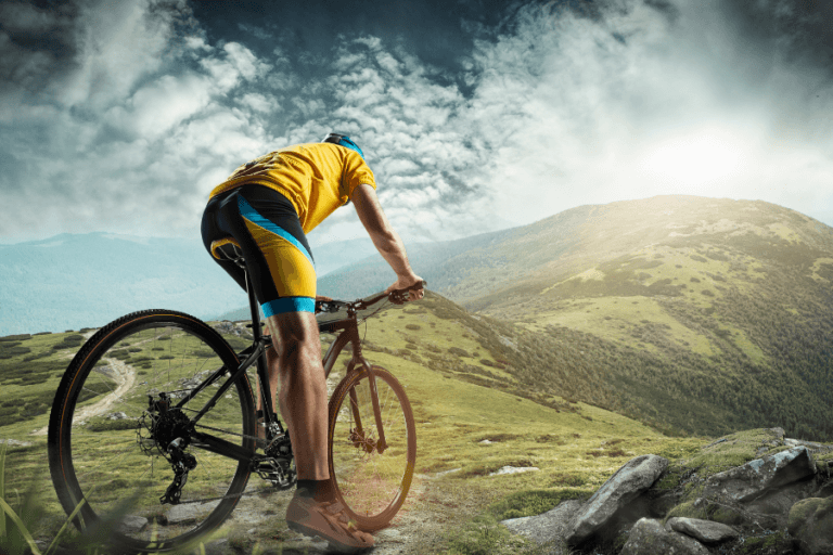 cyclist riding along mountain ridge